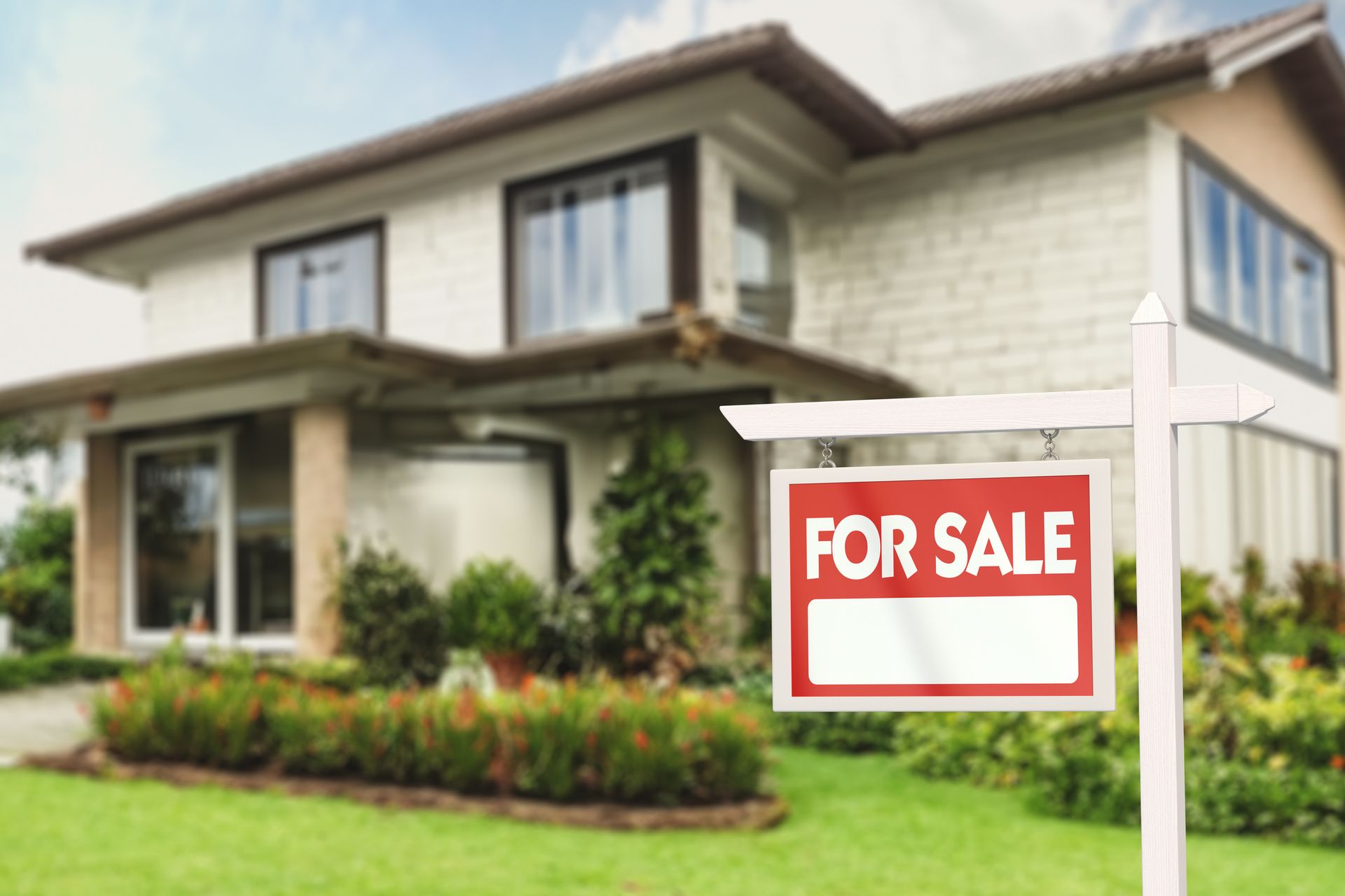 Real estate sign in front of a house with a garden for sale.