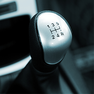 Close-up of a manual car gear shift knob with a 5-speed shift pattern