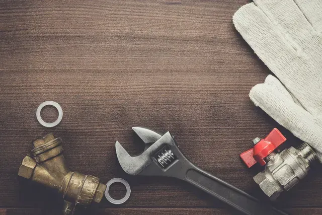 Close-up of plumbing tools on wood, highlighting plumbing services, ready for repairs. Close-up of plumbing tools on wood, highlighting plumbing services, ready for repairs.