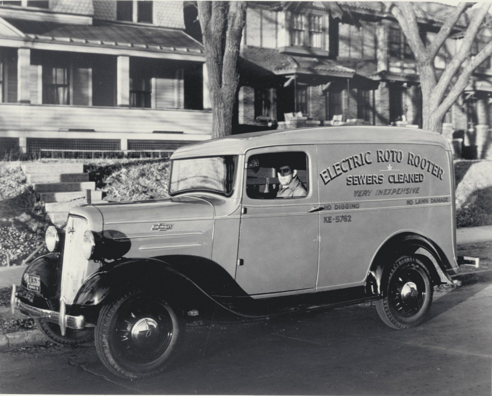 A black and white photo of an old electric route van