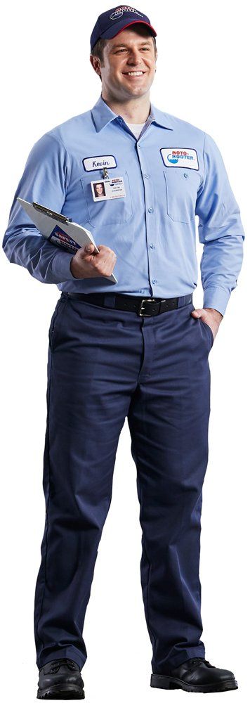A man in a blue shirt and blue pants is holding a clipboard.
