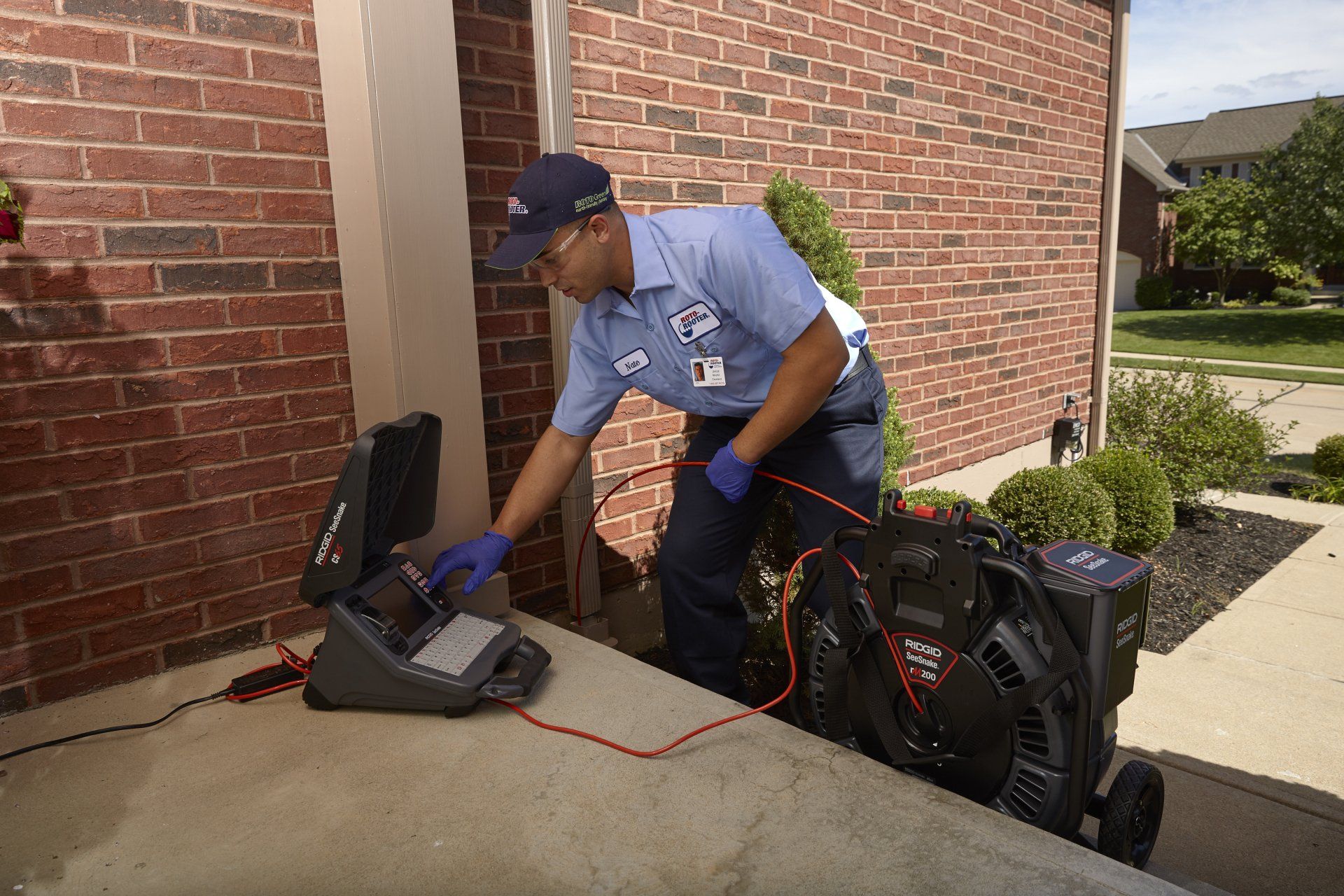 A man is using a camera to look at a drain in a house.