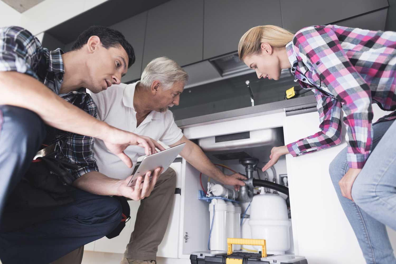 A woman shows plumbers a broken kitchen sink in Kalamazoo, MI by Roto-Rooter of Southwest Michigan your expert plumbing repair services A woman shows plumbers a broken kitchen sink in Kalamazoo, MI by Roto-Rooter of Southwest Michigan.