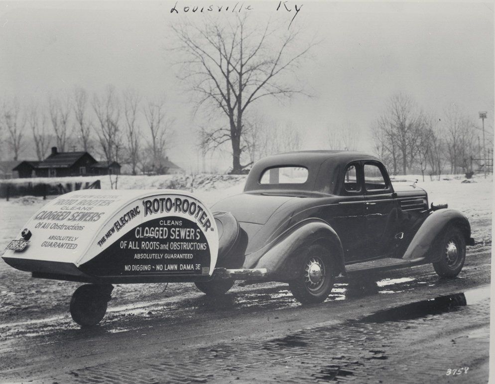 A black and white photo of a car that says roto rooter