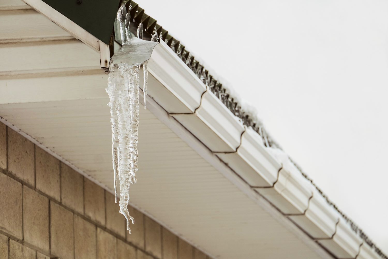 Icicles Are Hanging from The Gutter of A House — Coffs Coast Plumbing in Korora, NSW