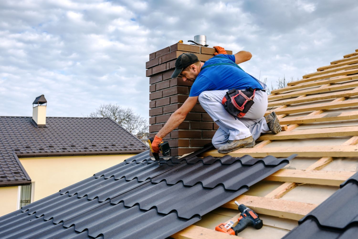 A Man Is Working on The Roof of A House — Coffs Coast Plumbing in Korora, NSW