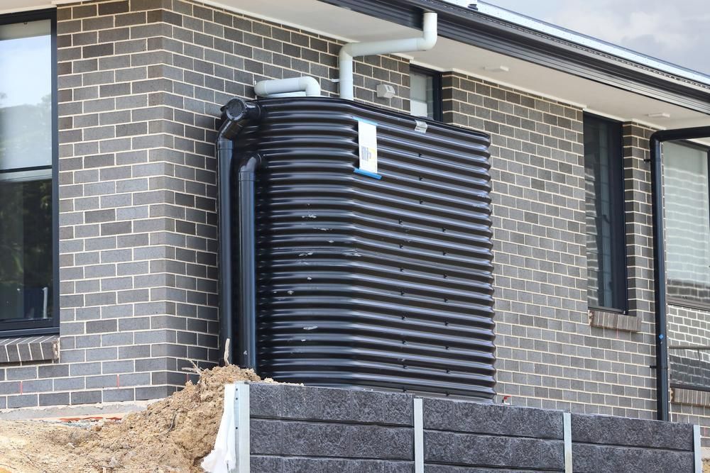A Brick House with A Black Water Tank — Coffs Coast Plumbing in Korora, NSW