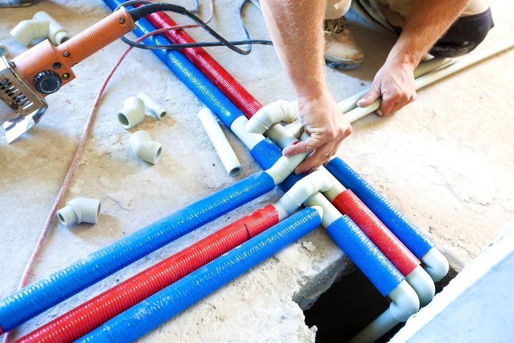 A Man Is Working on A Bunch of Pipes — Coffs Coast Plumbing in Korora, NSW