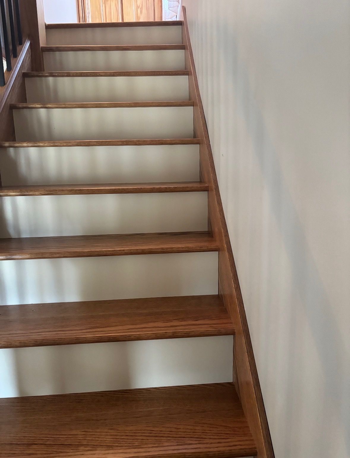 A wooden staircase with white risers ascending to a landing.