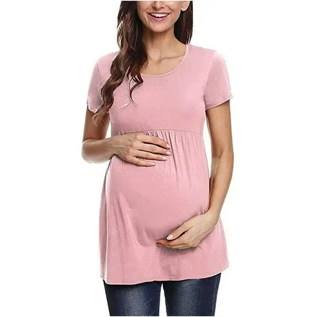 Mujer embarazada con una camisa rosa apoyando las manos sobre su vientre sobre un fondo blanco.