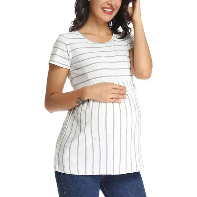 Mujer con una blusa de rayas blancas y vaqueros, sonriendo y tocándose el pelo.