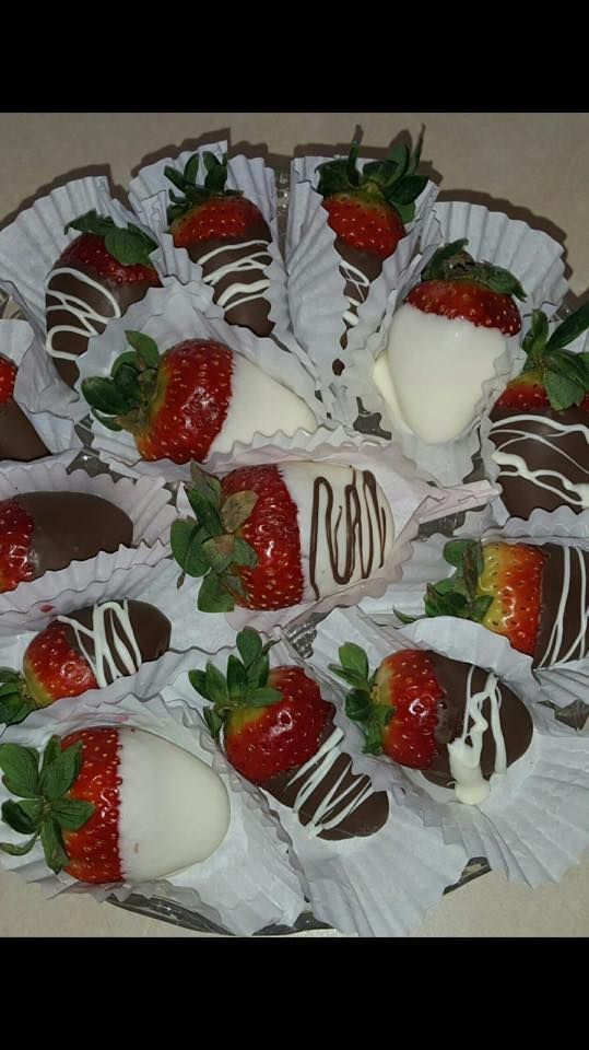 A tray of fresh strawberries, some dipped in white or dark chocolate, with white or dark chocolate drizzles.