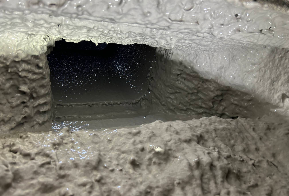 Snow-covered opening revealing a dark tunnel or hole in a snowy wall