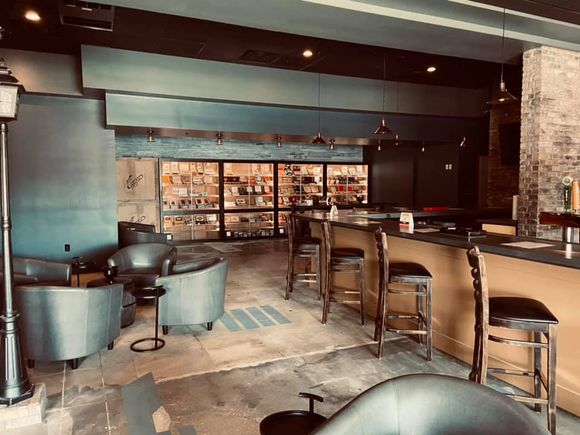 A large room with a bar and chairs in it