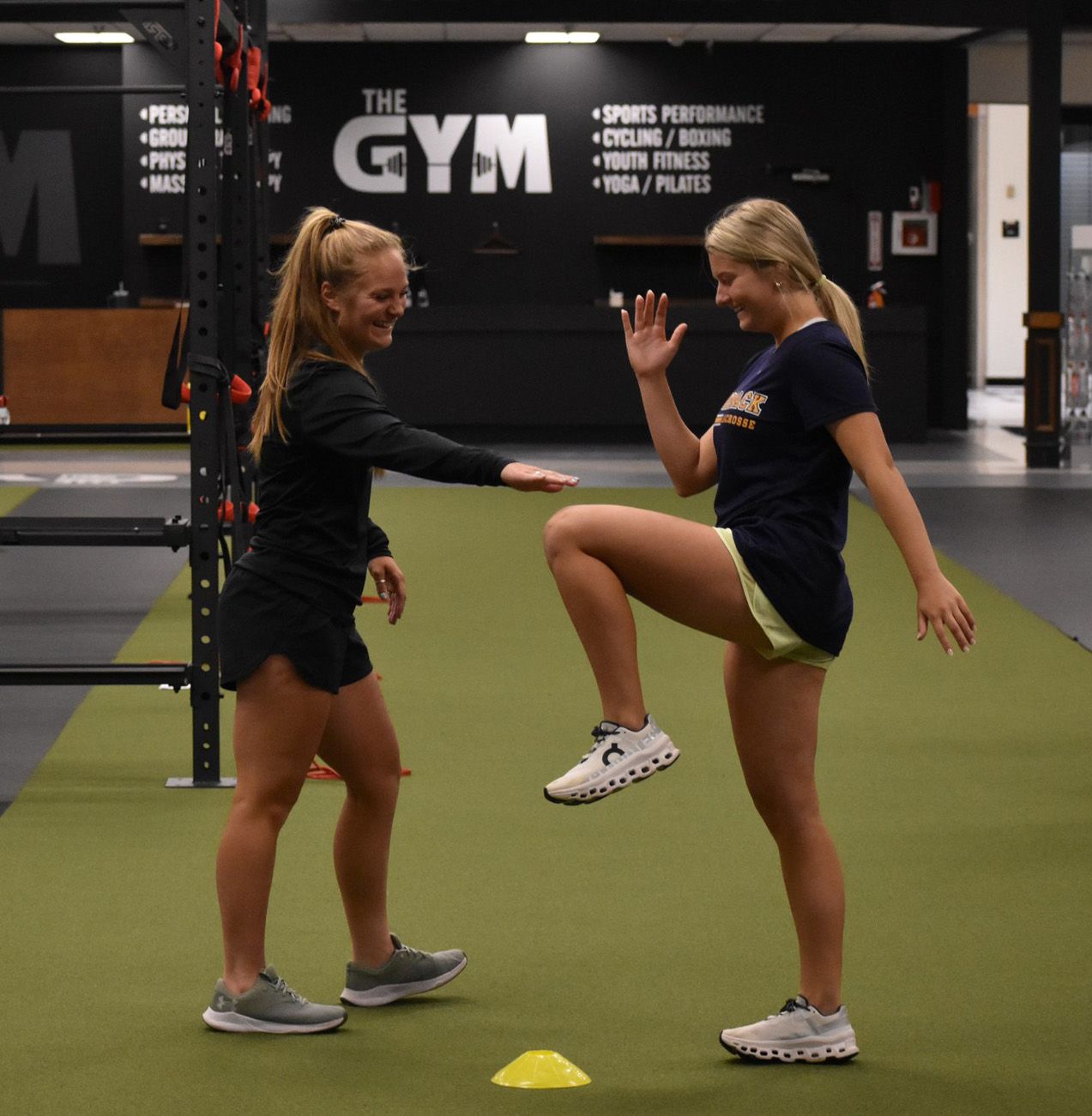 Two women are standing in front of a sign that says the gym