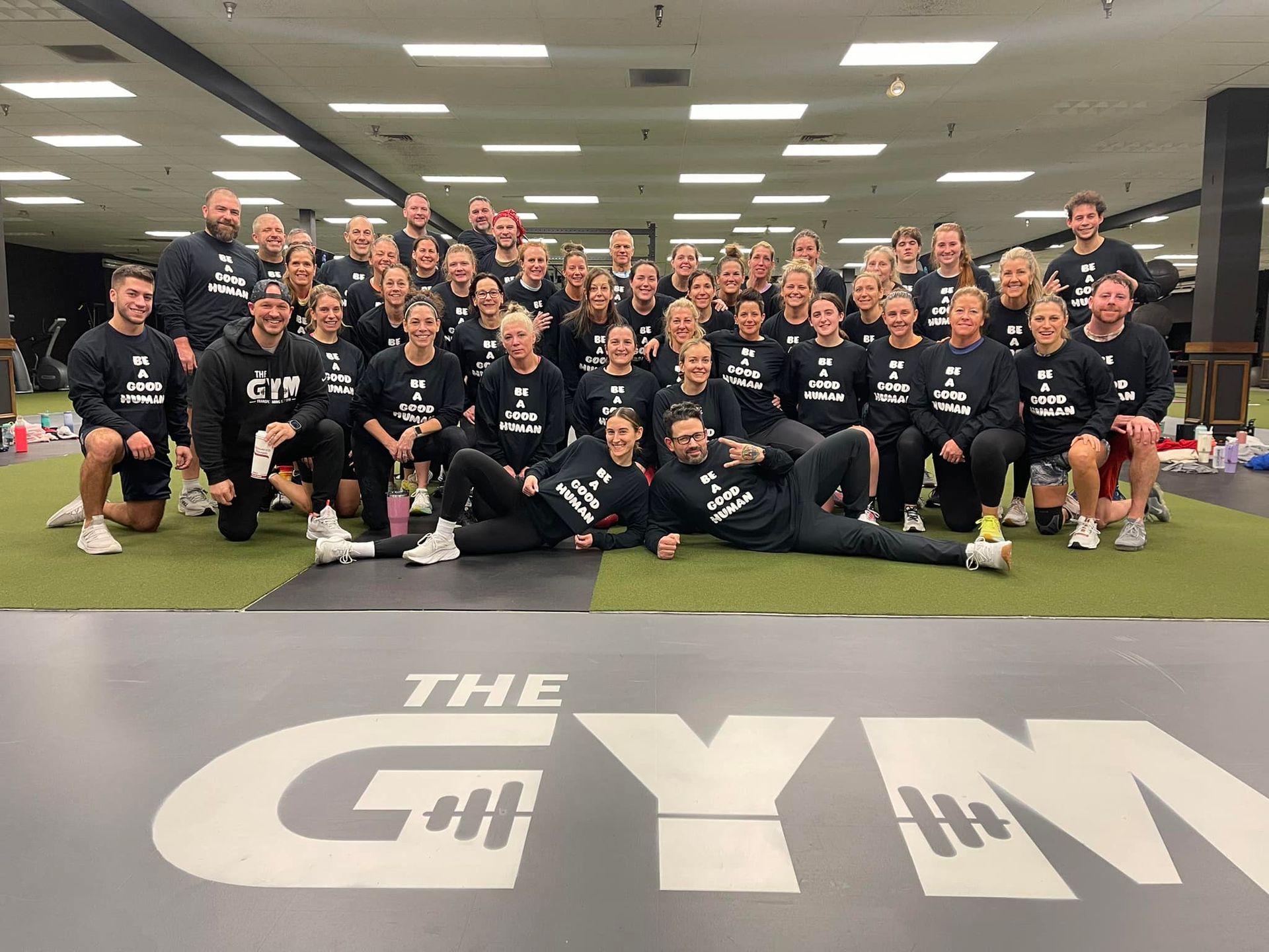 A large group of people are posing for a picture in a gym.