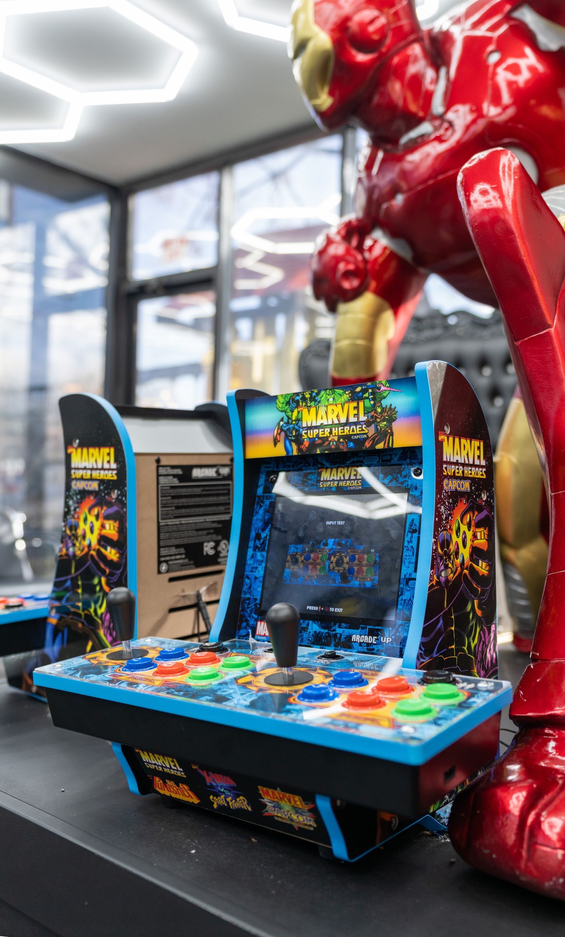 Colorful arcade racing game machine with bright blue controls and red decorations in a game room
