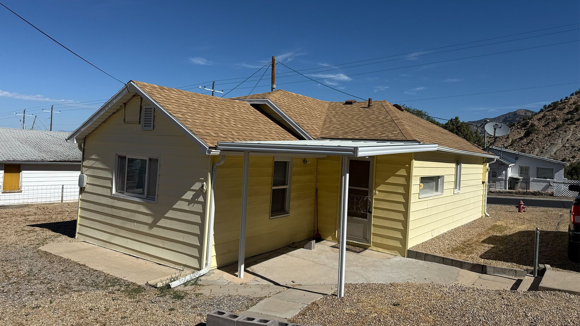 Exterior view of the yellow single-family home at 369 W 400 N in East Carbon, Utah.
