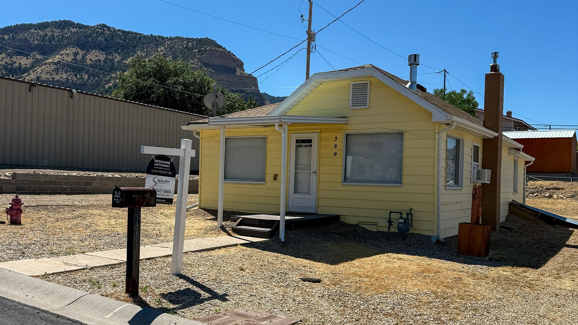 Front exterior view of the yellow single-family home at 369 W 400 N in East Carbon