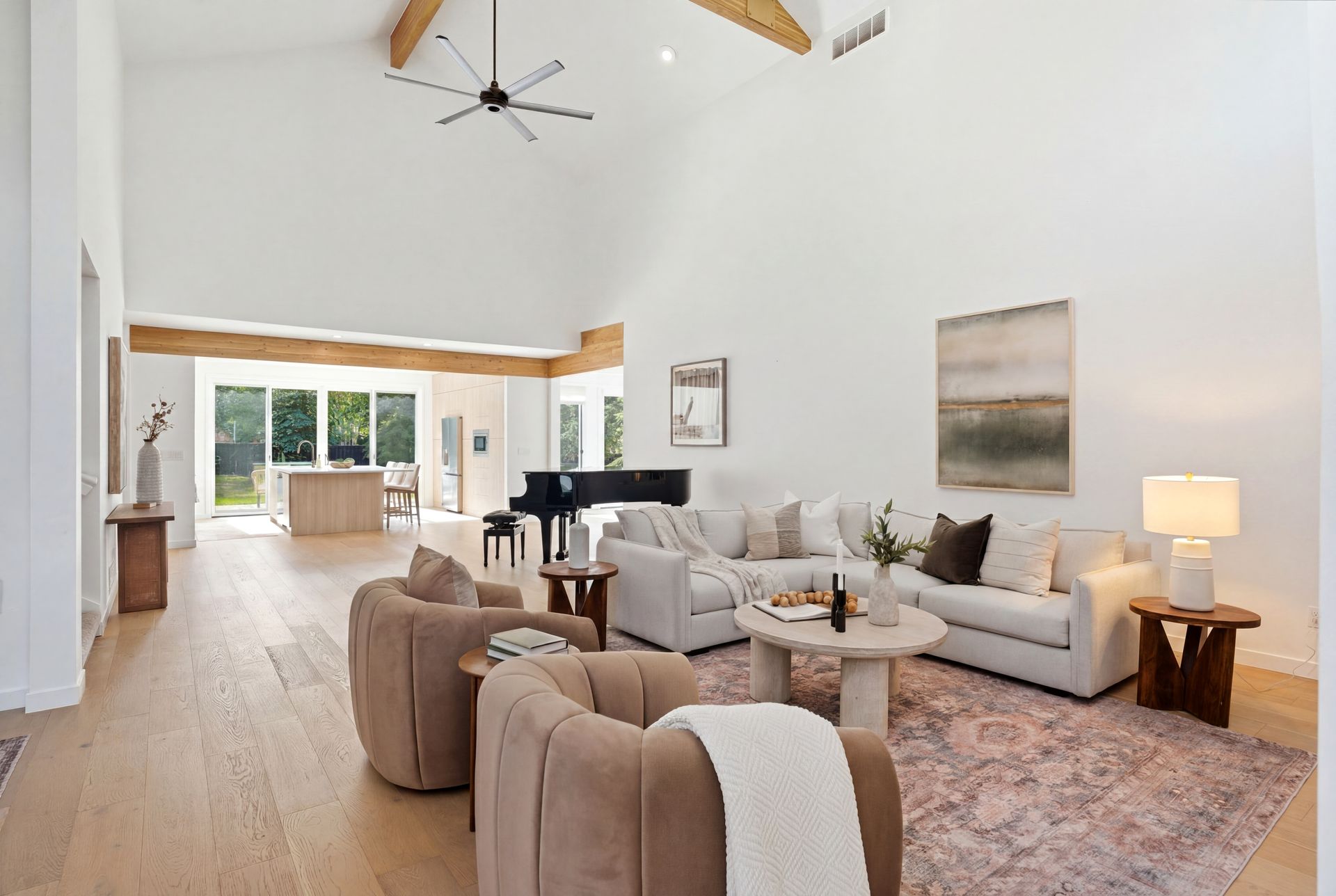 Open-concept living area with vaulted ceilings, exposed wood beams, and a view into the remodeled chef's kitchen at 5172 E Meadows Drive.