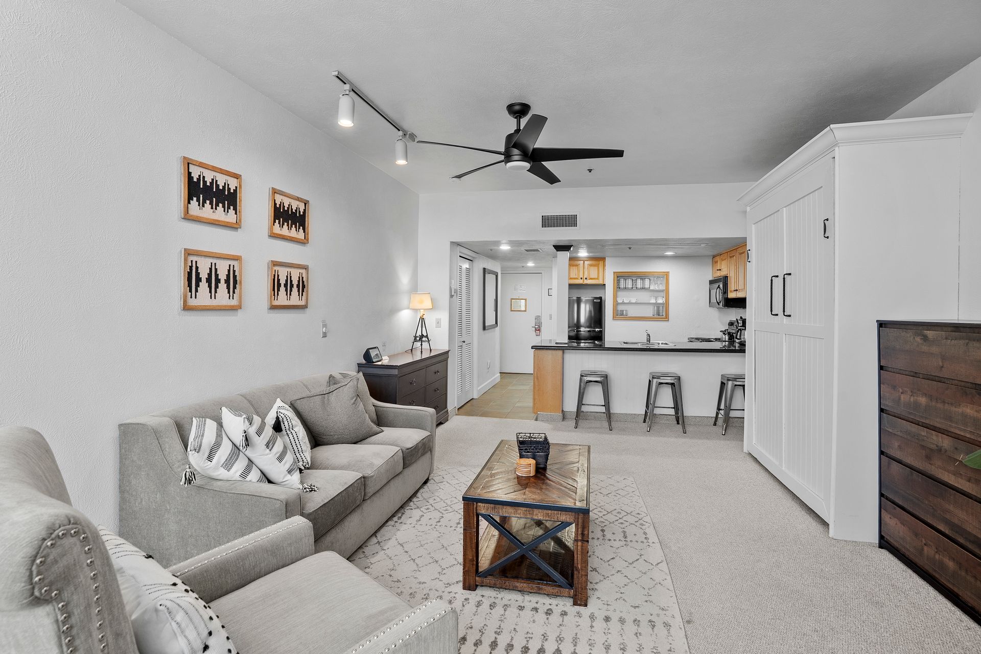 Cozy ski-in/ski-out studio living area at 1415 Lowell Ave in Park City, featuring a gas fireplace, kitchenette, Murphy bed, and a Price Improvement badge.