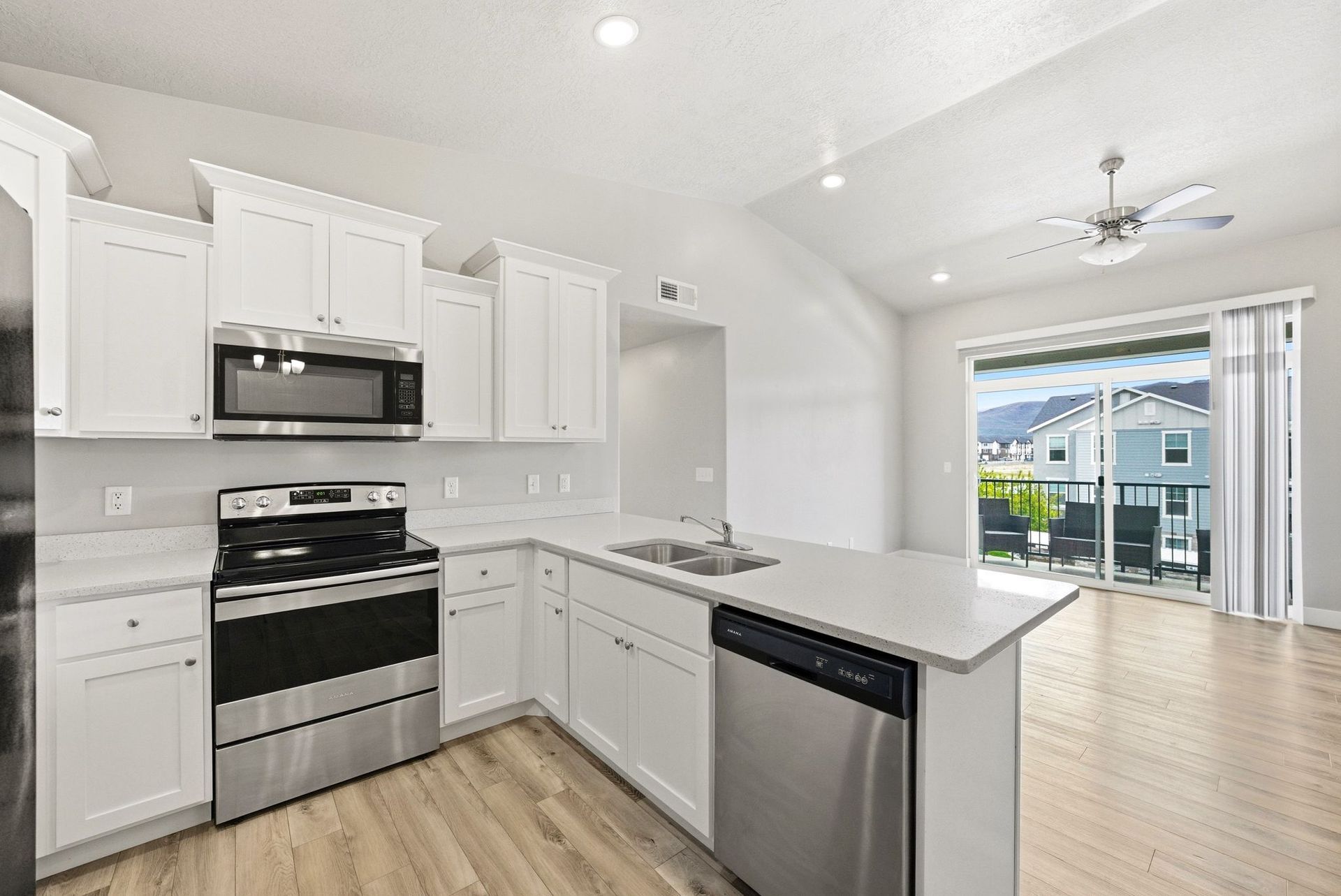 Bright, upgraded kitchen with white cabinets and stainless steel appliances at the Heber City condo for sale.