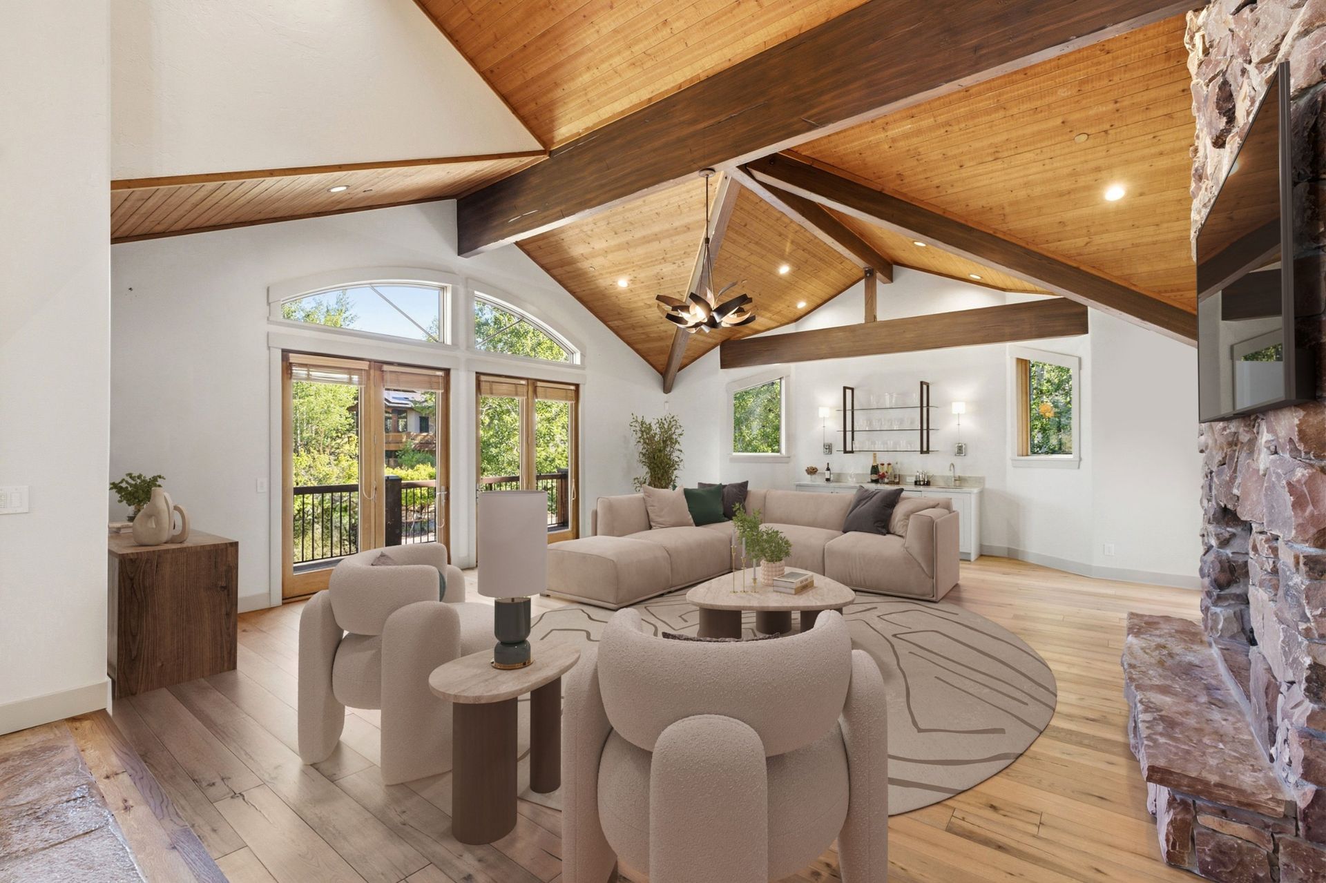 Virtually staged great room at 2490 Silver Cloud Dr with vaulted wood ceiling, sectional sofa, and arched windows