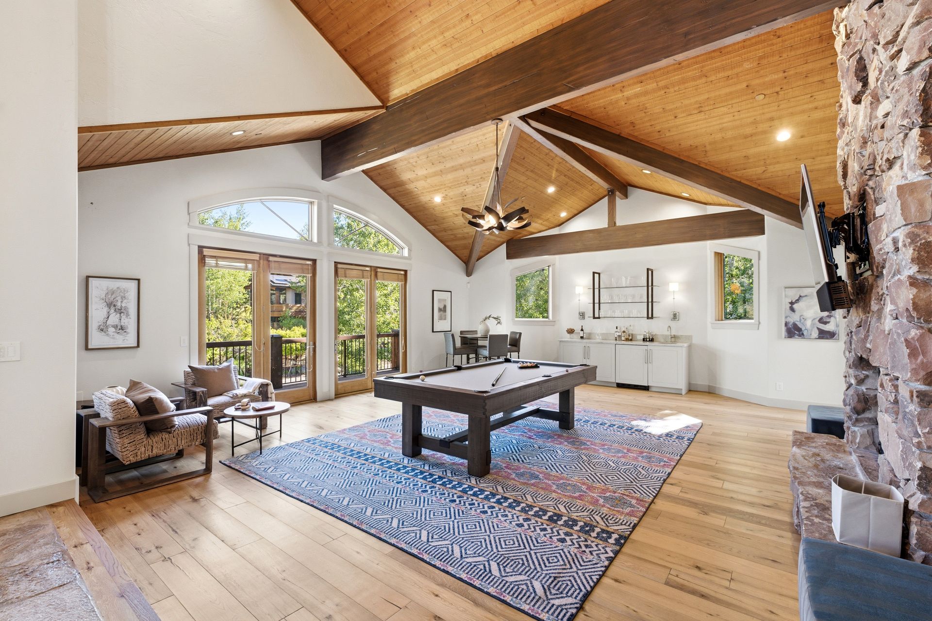 Spacious living room with hardwood floors, vaulted wood ceilings, and a pool table at the 2490 Silver Cloud Drive estate.