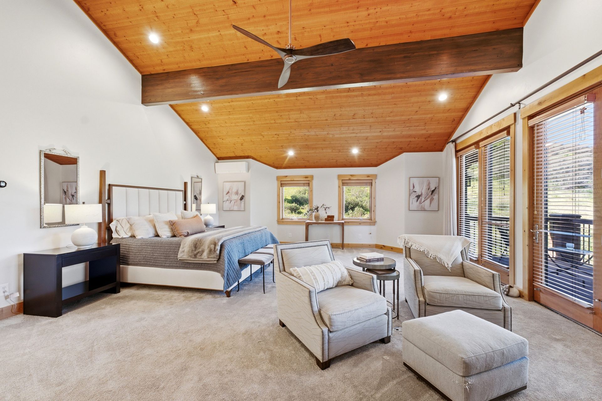 Primary suite at 2490 Silver Cloud Dr with vaulted wood ceiling, sitting area, and French doors to the deck