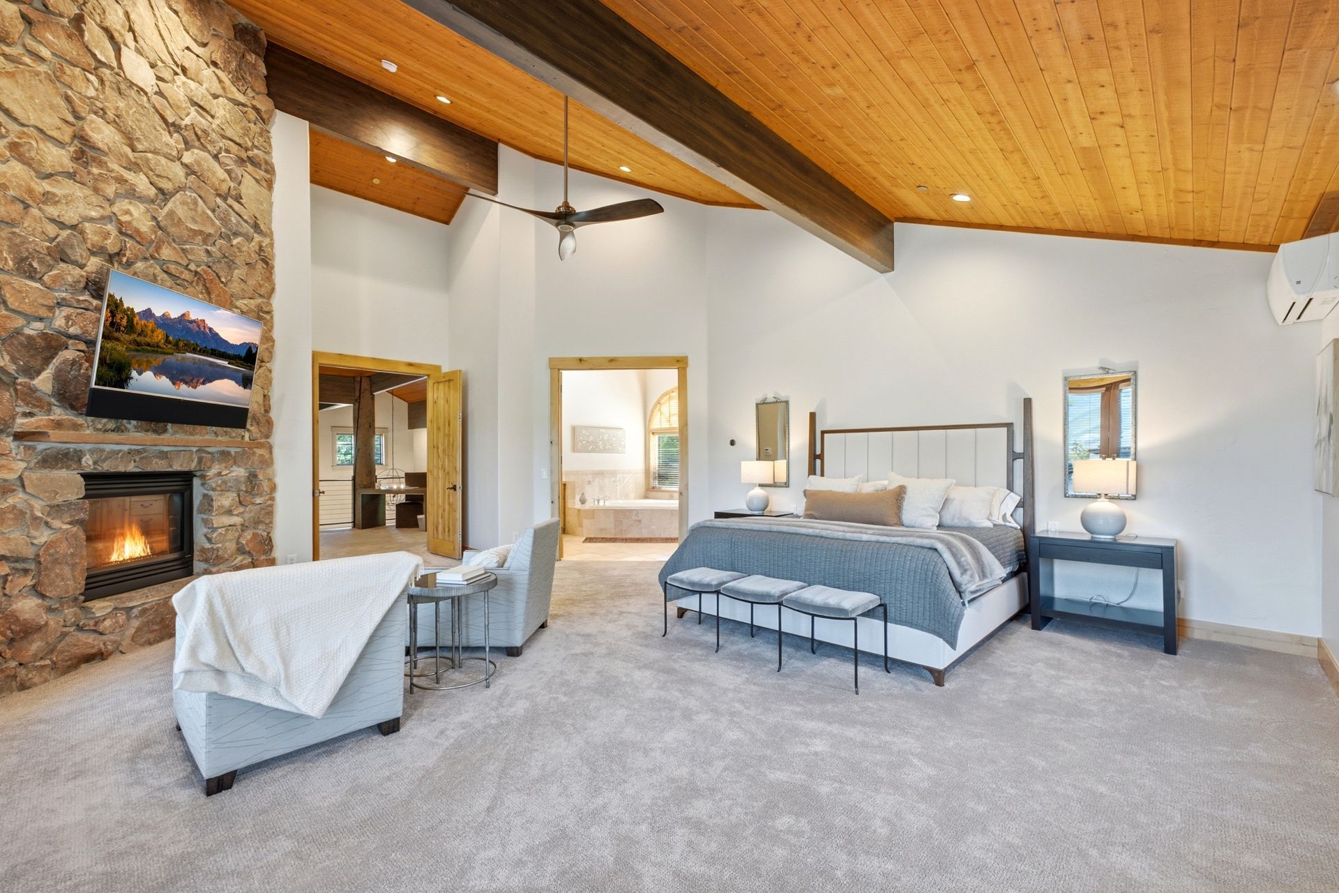 Spacious primary suite retreat featuring vaulted ceilings, fireplace, and private mountain views.