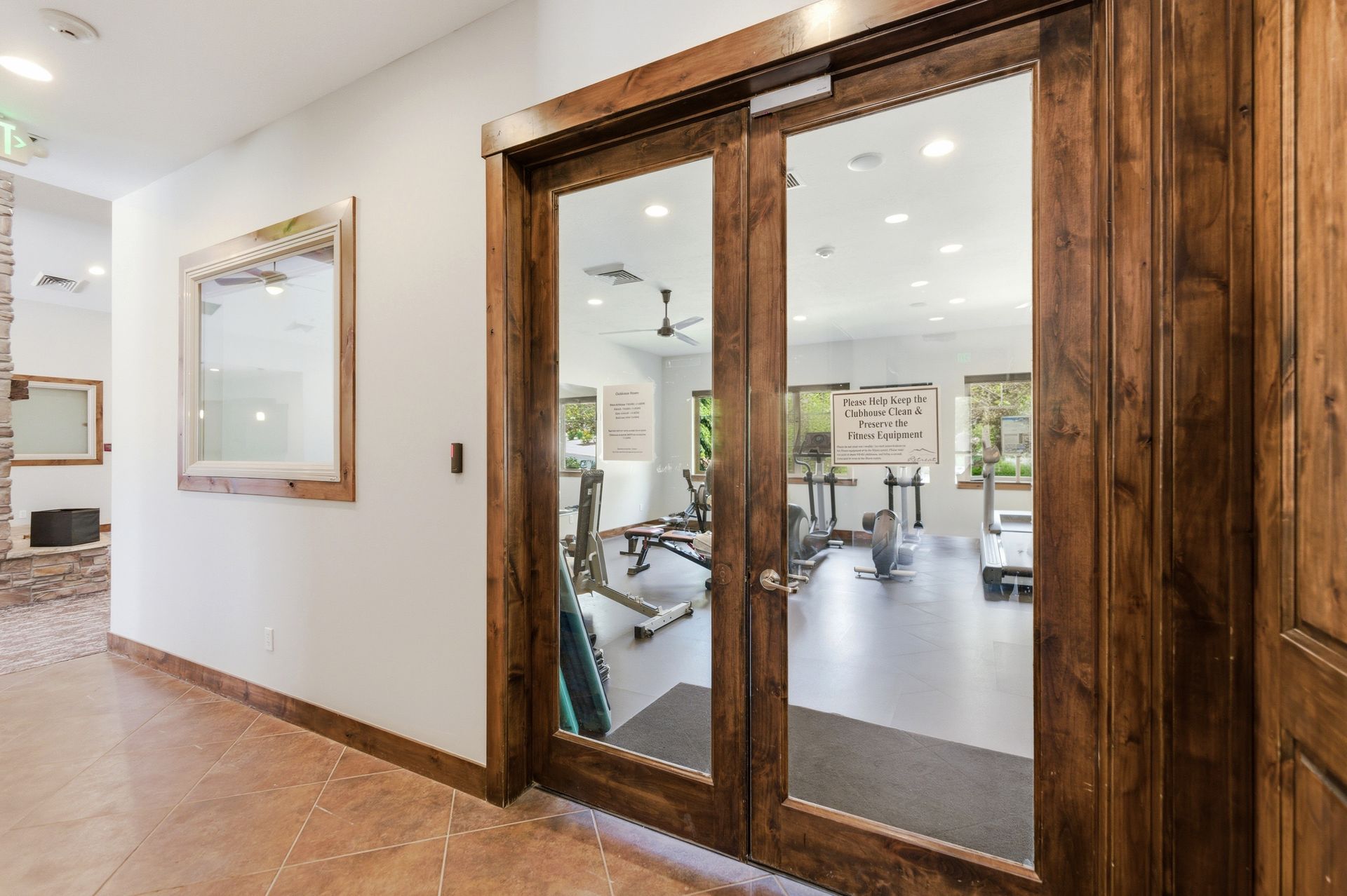 Glass doors leading to the fully equipped fitness center in the Park's Edge community clubhouse.