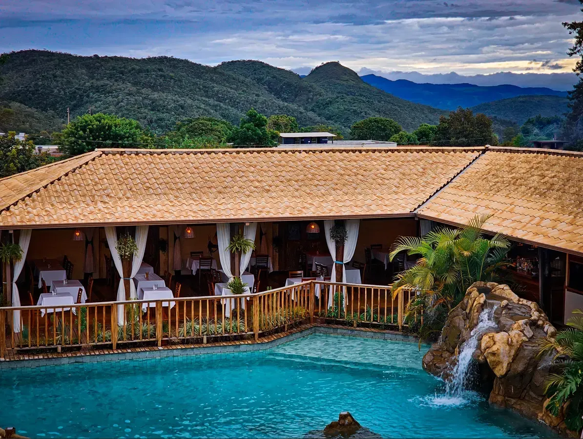 Há uma grande piscina no meio do jardim. pousada-dos-guias