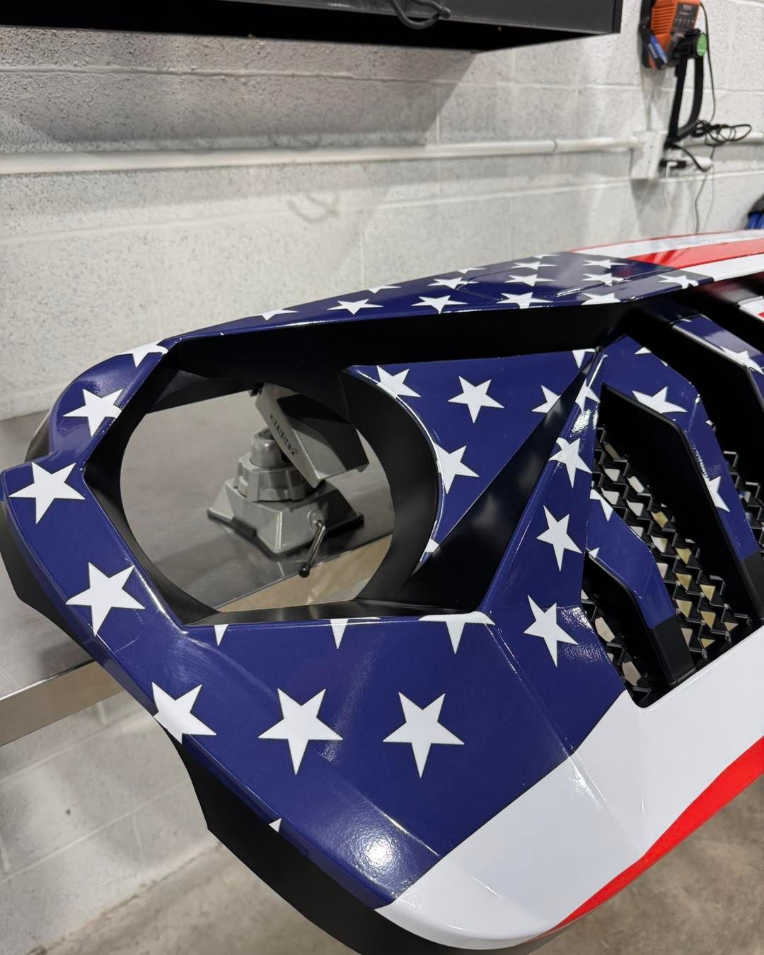 American flag-themed vehicle body panel with star decals and a headlight opening
