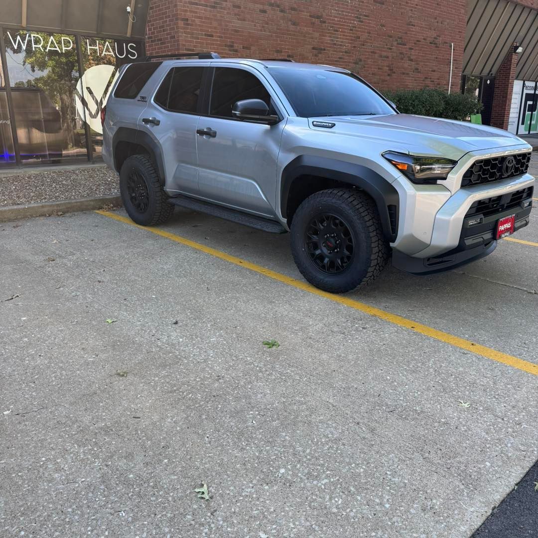 Silver pickup truck parked beside a brick wall in a paved lot