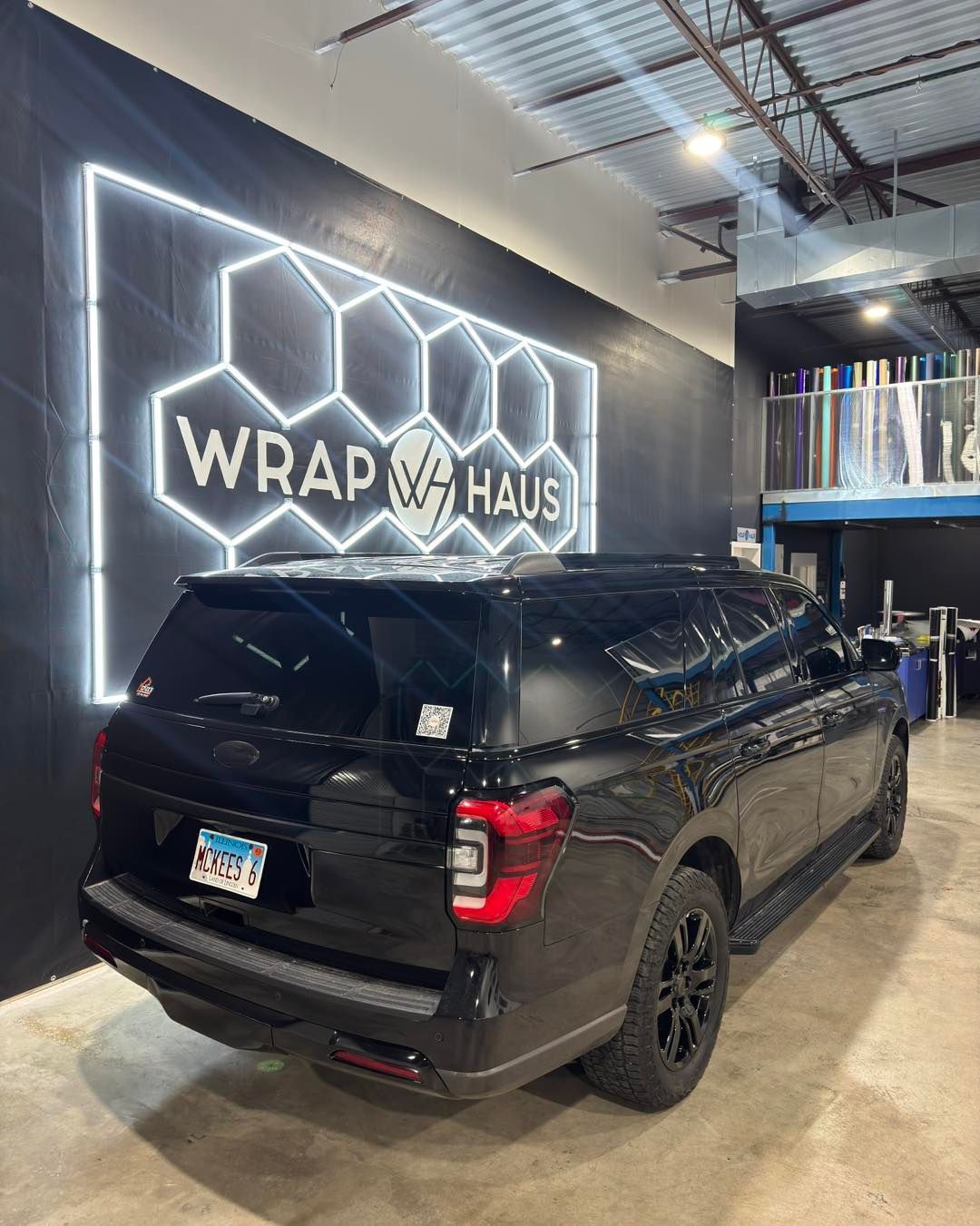 Black pickup truck in a garage with a neon