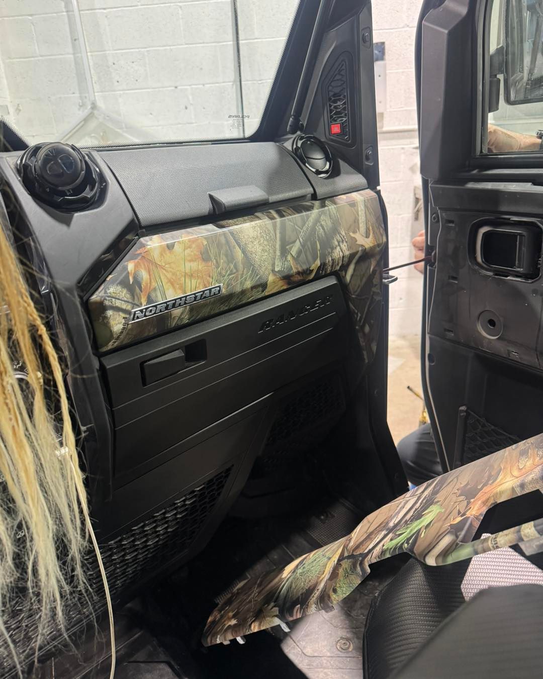 Damaged car interior with deployed camouflage airbags and torn passenger seat upholstery