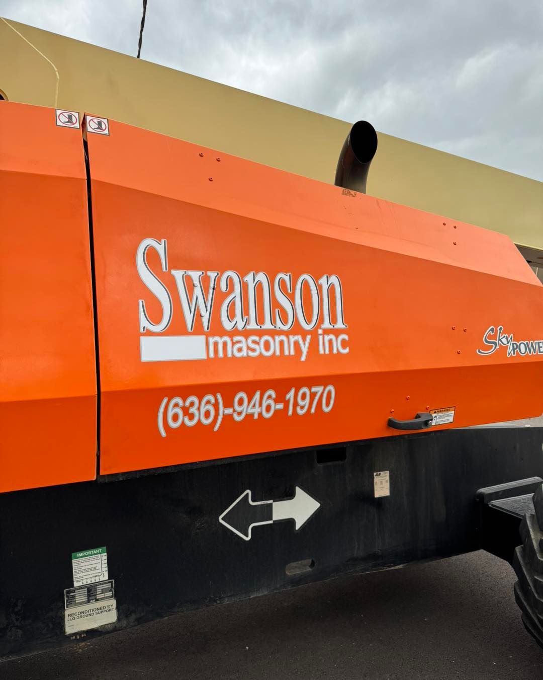 Orange Swanson Masonry Inc. truck with company name and phone number on the side