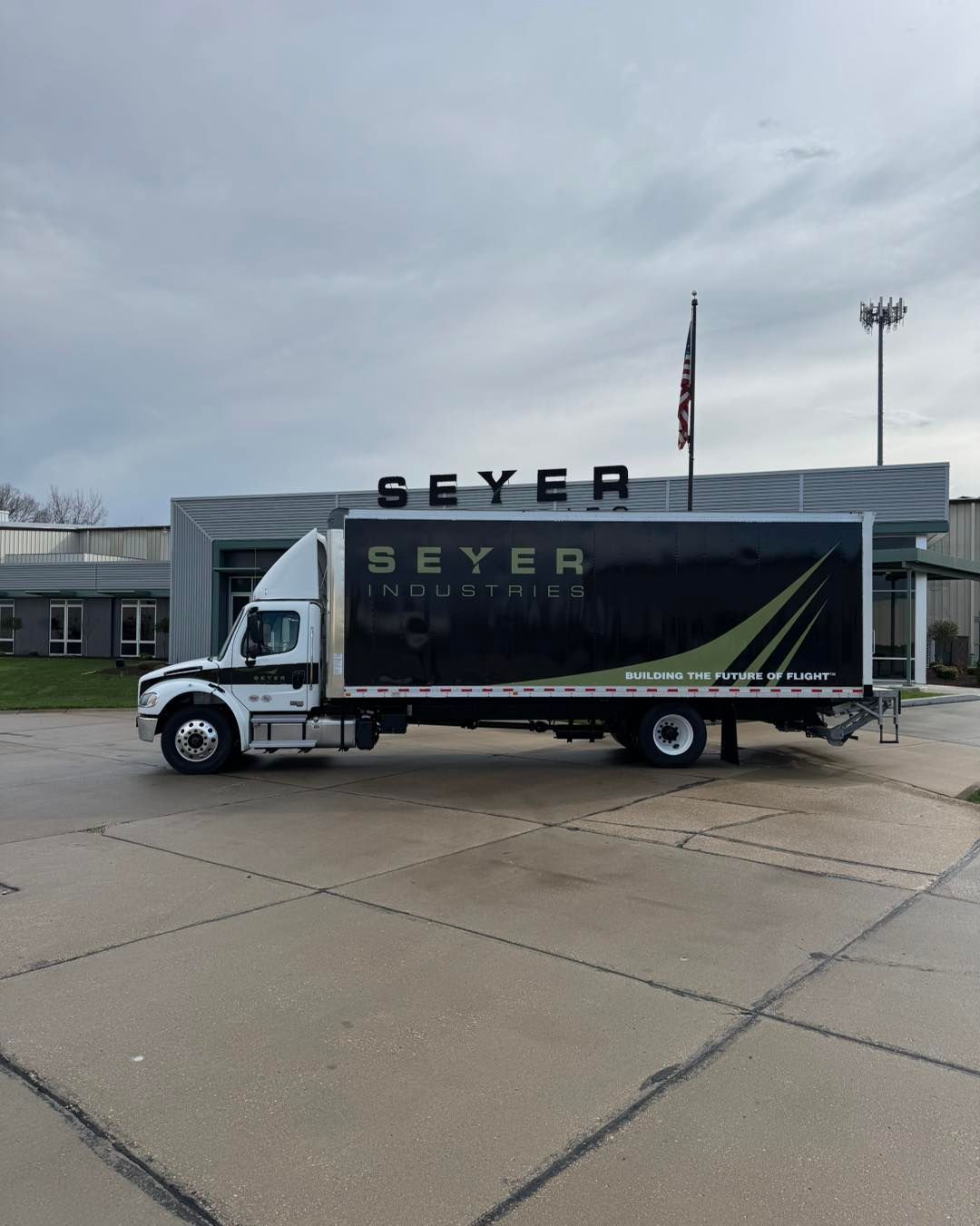 Seyer logoed box truck parked in front of a building on a cloudy day