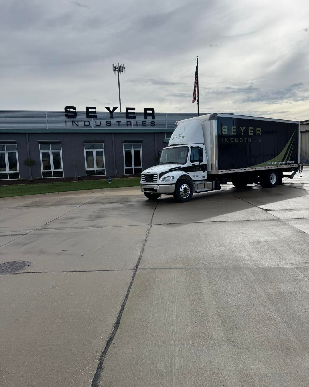 Black Seyer Industrial truck parked outside a Seyer Industrial building on a cloudy day