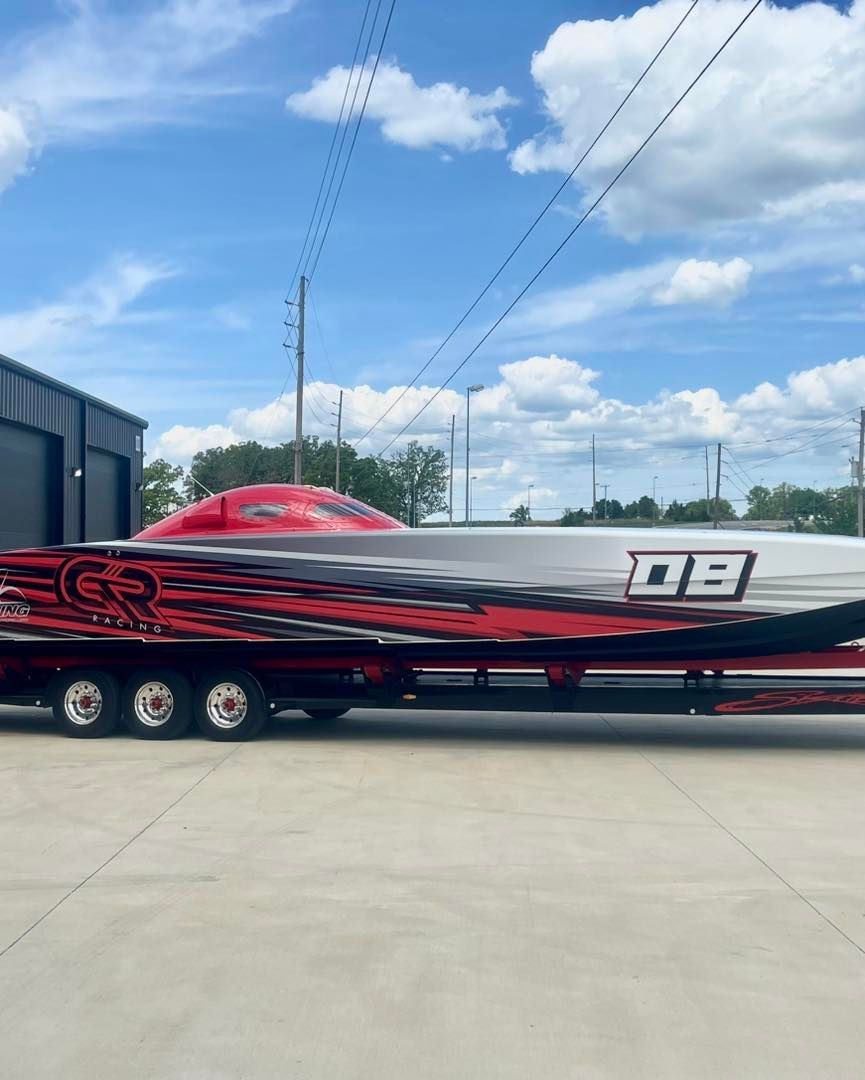 Black and red speedboat on a trailer under a blue sky, with number 08 on the side