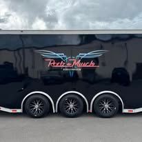 Black enclosed trailer with three wheels and a neon-style logo on the side