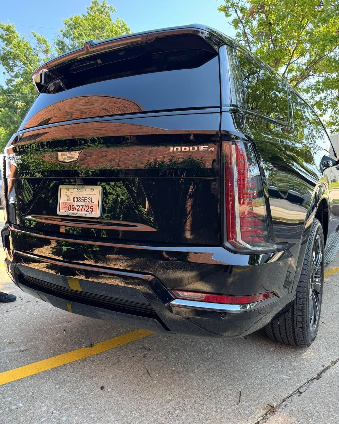 Black SUV parked on a street, rear view, with tinted windows and a Texas license plate.