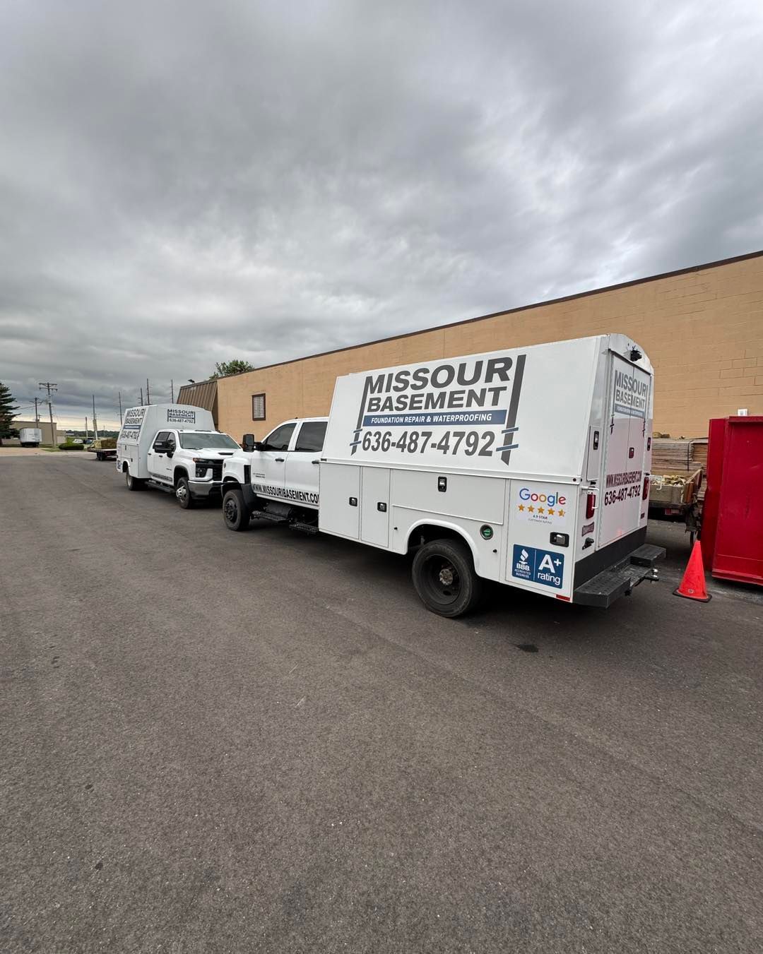 White moving truck with “Missouri Movement” parked beside a tan building under a cloudy sky.