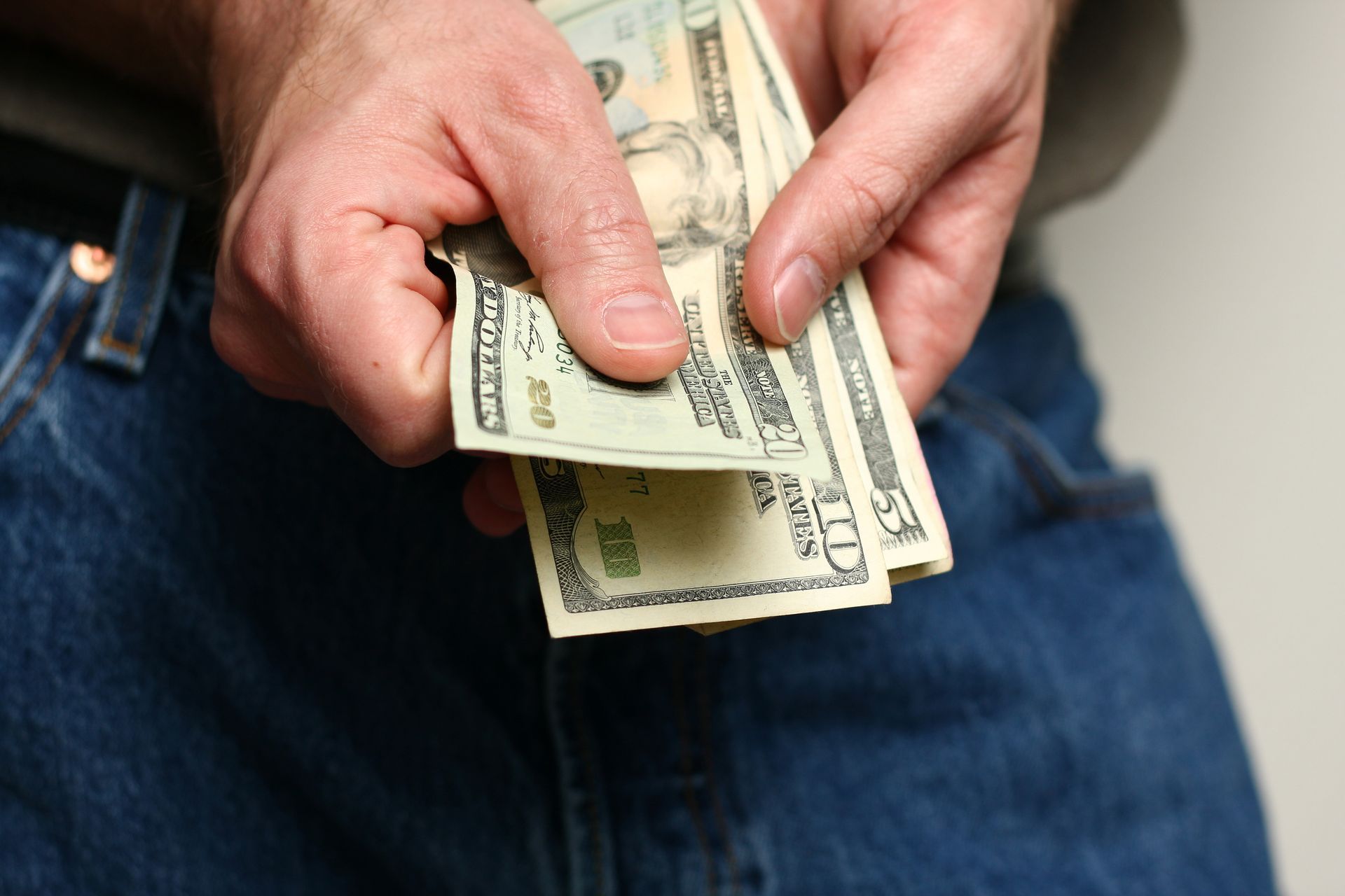 Person counting cash for quick cash needs from payday loan services. Person counting cash for quick cash needs from payday loan services.