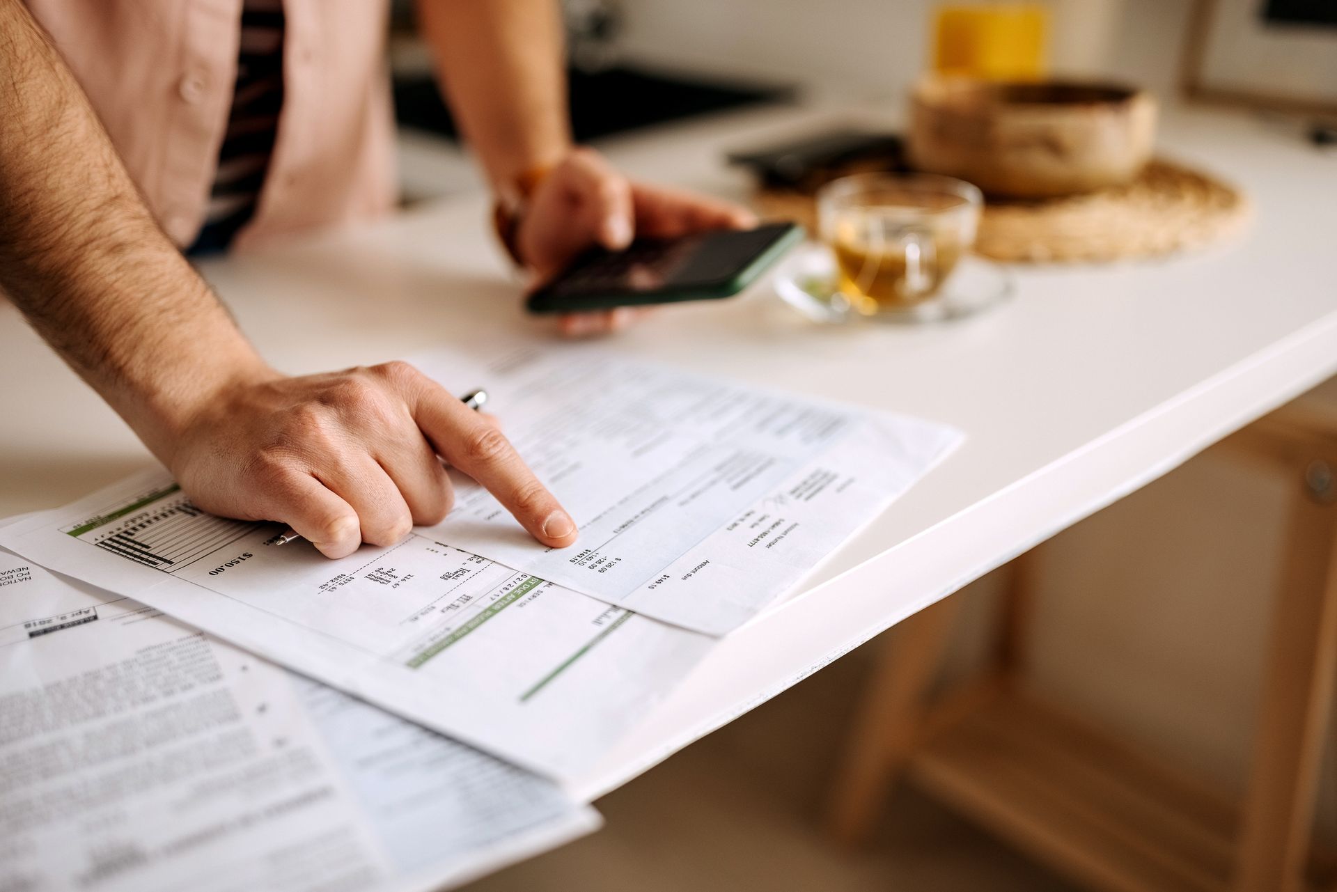 Man using calculator on the phone to calculate expenses.