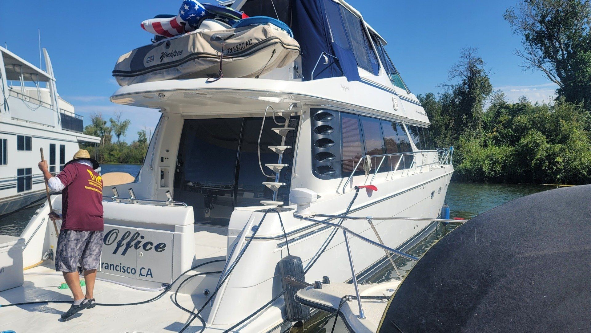 A man is standing in front of a boat that says office on the side.