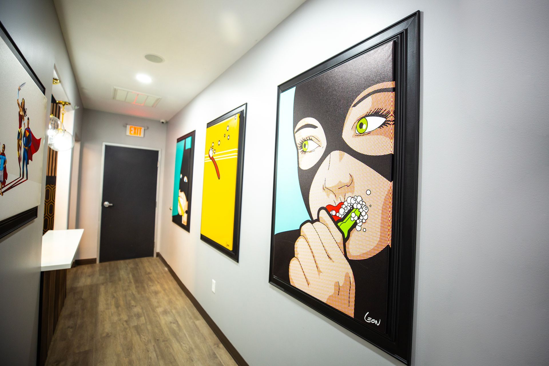 Super Dentists in San Antonio A hallway with a painting of a woman in a mask on the wall.
