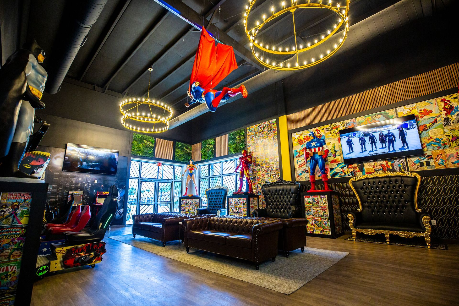 Super Dentists in San Antonio A living room with a couch , chairs , and a superhero statue hanging from the ceiling.