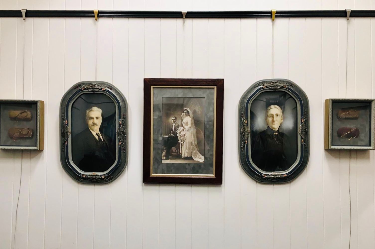 A hanging gallery, in a private residence, of family heirloom photos and objects, framed and hung by ARTSHOP Toowoomba.