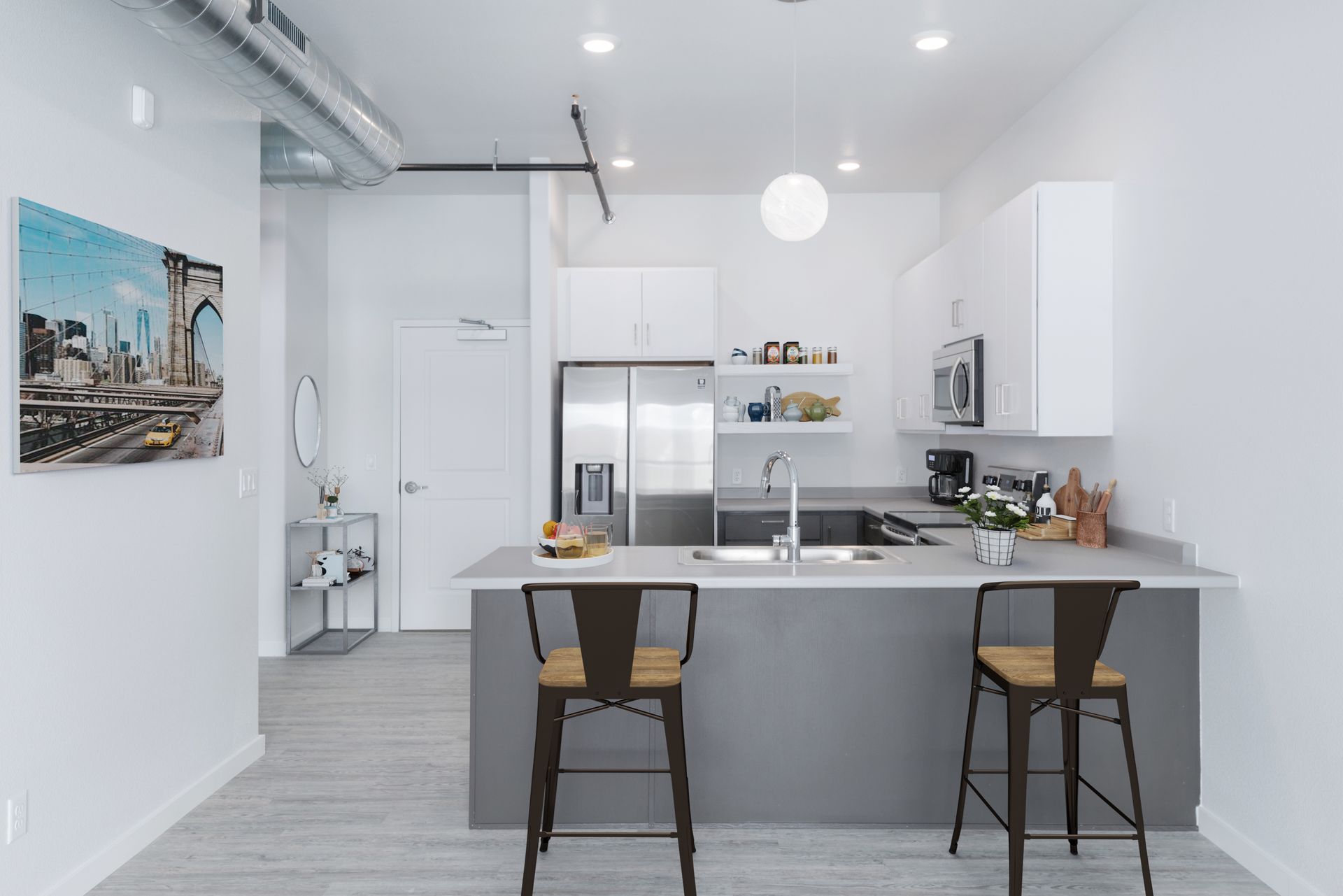 Bright modern kitchen with white cabinets, gray island, stainless appliances, and two stools